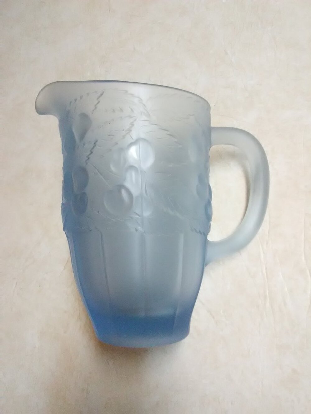 Vintage blue satin frosted pitcher with raised cherries design - about 7 1/2"